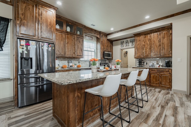 kitchen featuring a kitchen island, appliances with stainless steel finishes, and backsplash