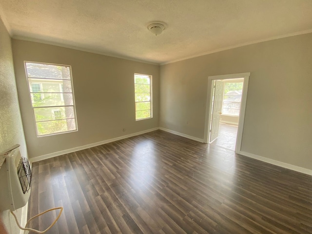 empty room with ornamental molding, dark hardwood / wood-style floors, and a textured ceiling