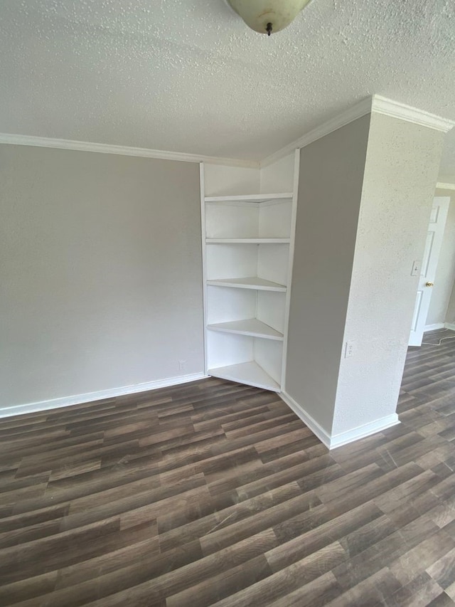 spare room with dark wood-type flooring, crown molding, and a textured ceiling