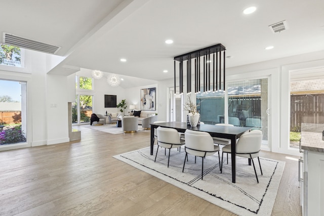 dining area featuring light hardwood / wood-style floors, high vaulted ceiling, and a healthy amount of sunlight