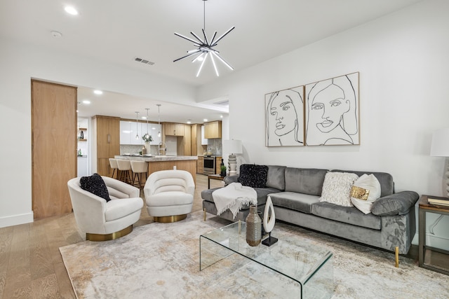 living room featuring a notable chandelier and light wood-type flooring