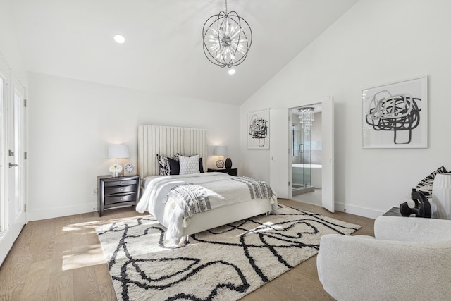 bedroom featuring hardwood / wood-style floors, high vaulted ceiling, an inviting chandelier, and ensuite bath