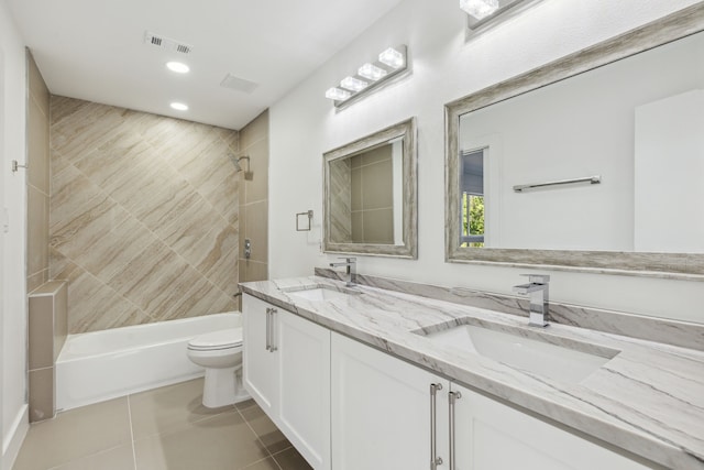 full bathroom featuring tiled shower / bath, vanity, toilet, and tile patterned flooring