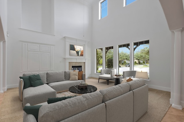 living room with light carpet, a high ceiling, and decorative columns