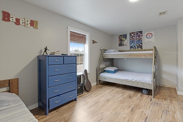 bedroom featuring visible vents, baseboards, and light wood-style floors