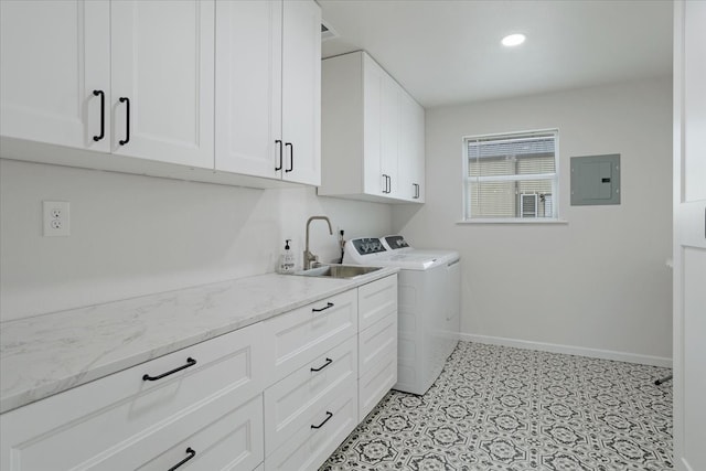 washroom with baseboards, electric panel, cabinet space, separate washer and dryer, and a sink