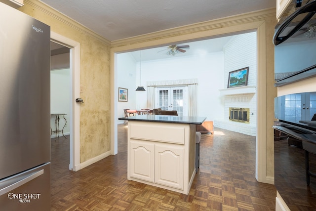 kitchen featuring stainless steel fridge, dark parquet floors, ceiling fan, white cabinetry, and black oven