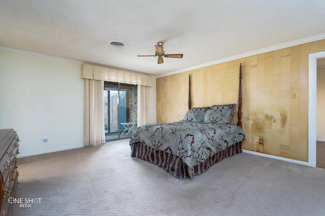 carpeted bedroom featuring crown molding, a textured ceiling, wooden walls, and ceiling fan