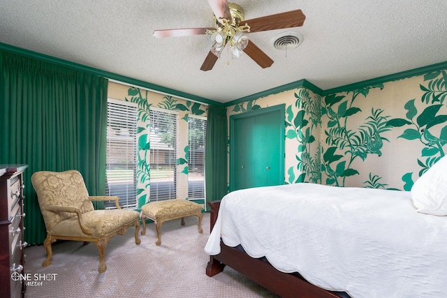 carpeted bedroom featuring crown molding, a textured ceiling, and ceiling fan