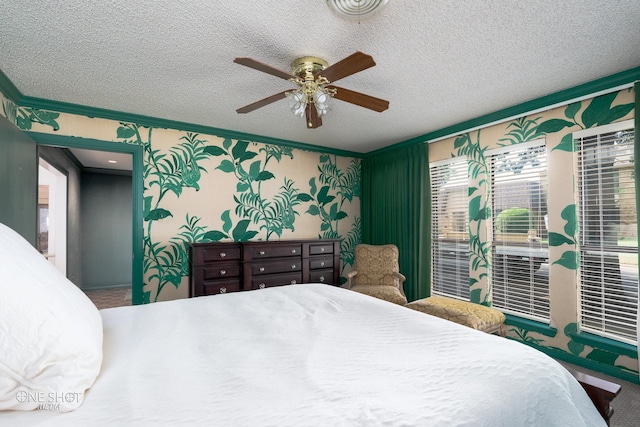 bedroom featuring ceiling fan, crown molding, and a textured ceiling