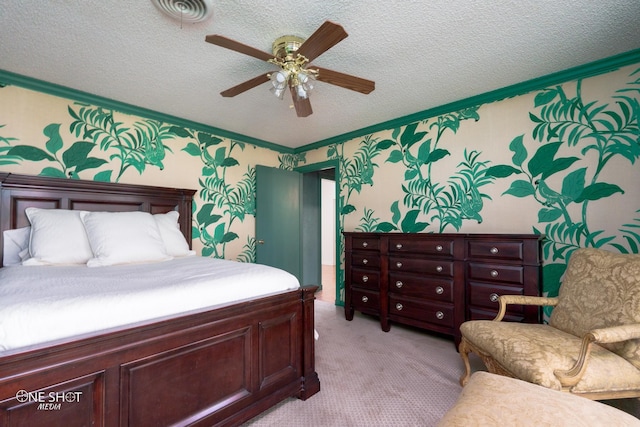 bedroom with ceiling fan, a textured ceiling, ornamental molding, and light colored carpet