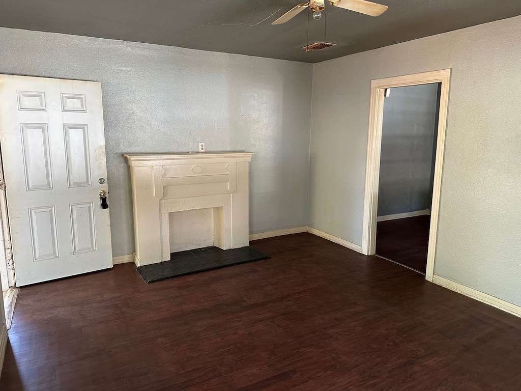 unfurnished living room with dark wood-type flooring and ceiling fan