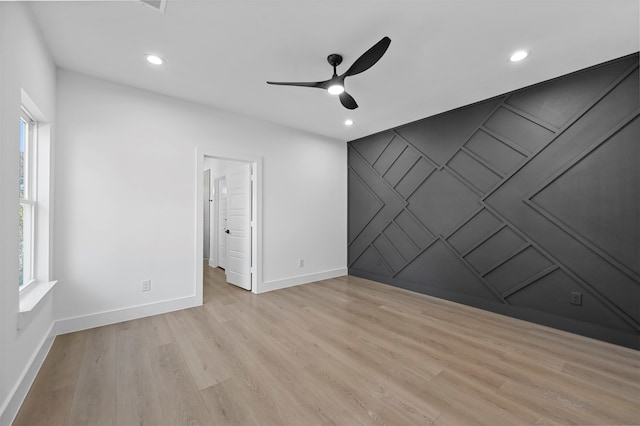 empty room featuring light wood-type flooring, a healthy amount of sunlight, and ceiling fan