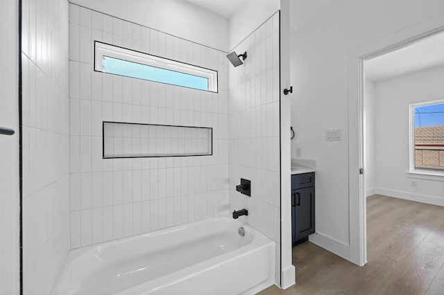 bathroom featuring a wealth of natural light, vanity, and tiled shower / bath combo