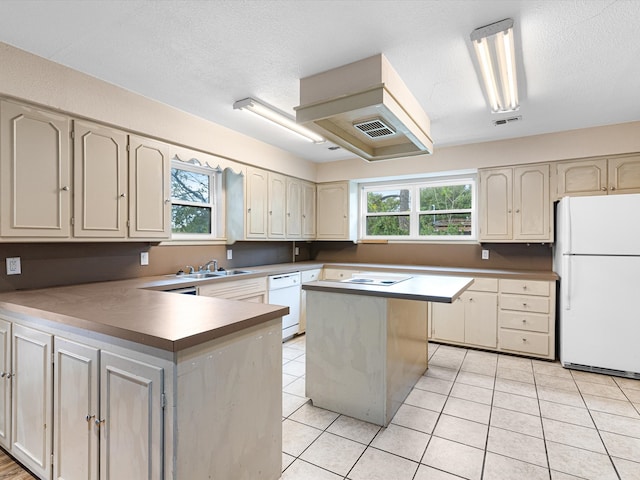 kitchen with sink, white appliances, plenty of natural light, and a center island