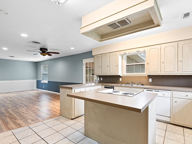 kitchen with white appliances, a center island, and light tile patterned floors