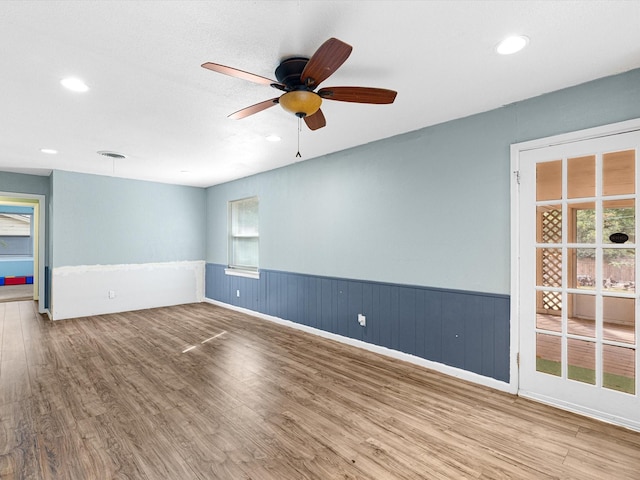 spare room with wood-type flooring, plenty of natural light, and ceiling fan