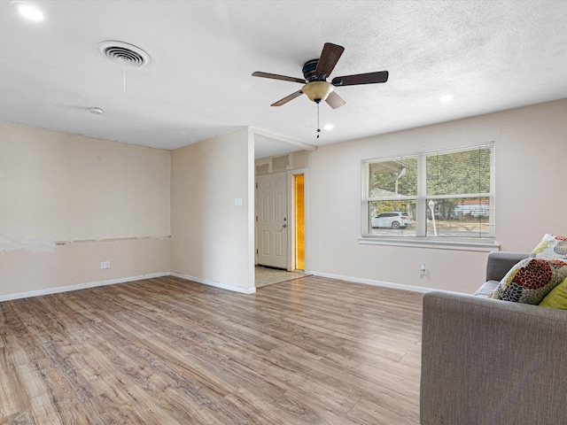 unfurnished room featuring ceiling fan, light hardwood / wood-style floors, and a textured ceiling