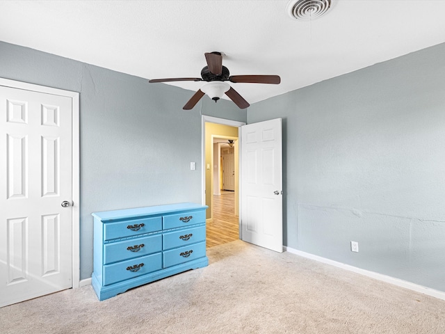 unfurnished bedroom with ceiling fan and light carpet