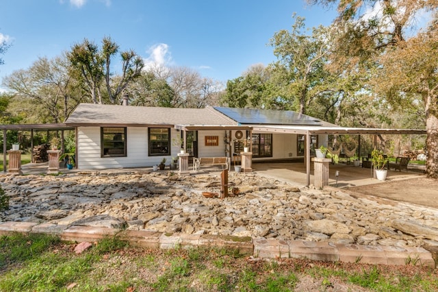 view of front of home featuring solar panels and a patio