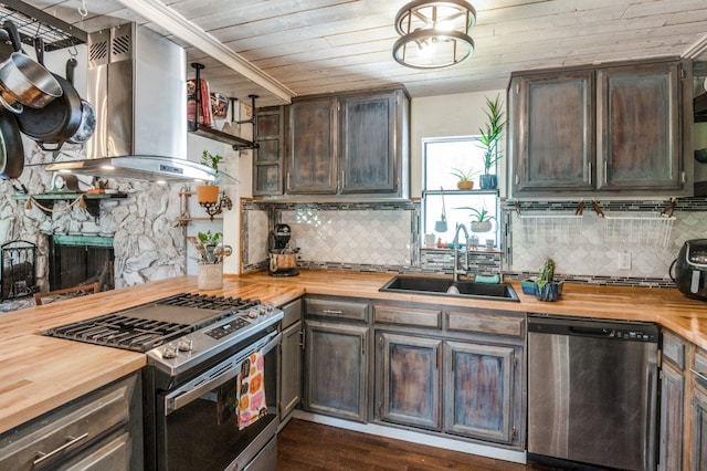 kitchen featuring butcher block counters, sink, dark hardwood / wood-style floors, island exhaust hood, and appliances with stainless steel finishes