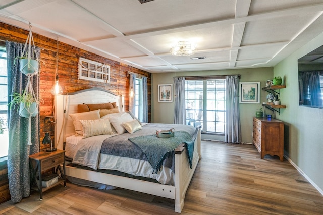 bedroom with beam ceiling, coffered ceiling, and hardwood / wood-style flooring