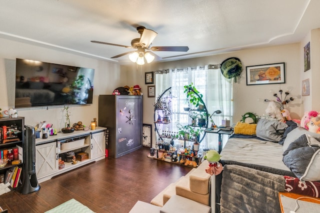 living room with ceiling fan, dark wood-type flooring, and a textured ceiling