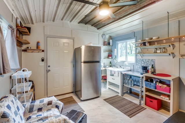 kitchen with vaulted ceiling, stainless steel refrigerator, ceiling fan, and wood ceiling