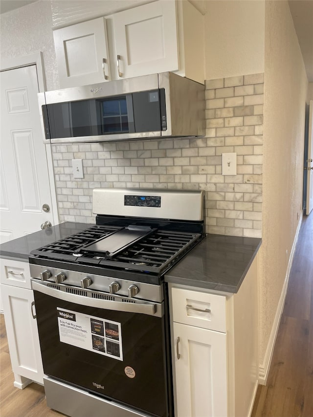 kitchen featuring white cabinetry, stainless steel appliances, and light hardwood / wood-style floors