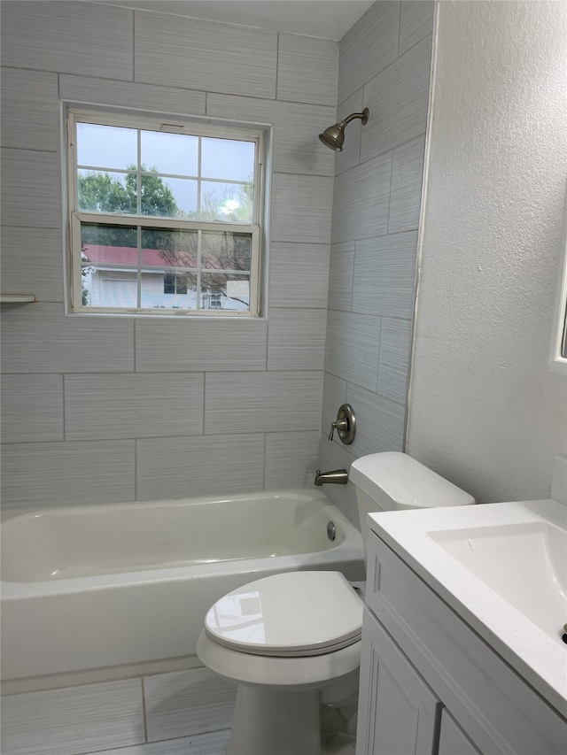 full bathroom with vanity, tiled shower / bath combo, and toilet