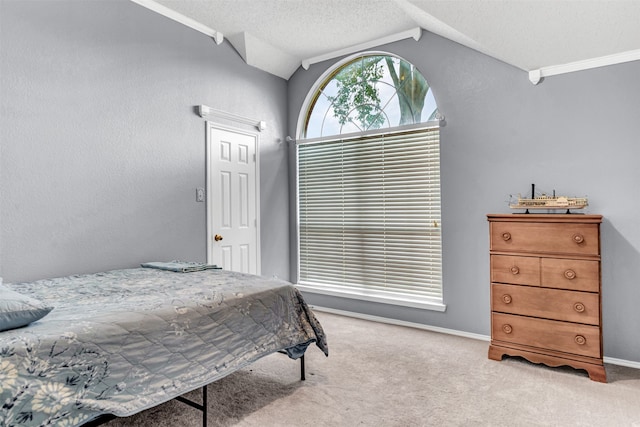 bedroom with light carpet, ornamental molding, and lofted ceiling