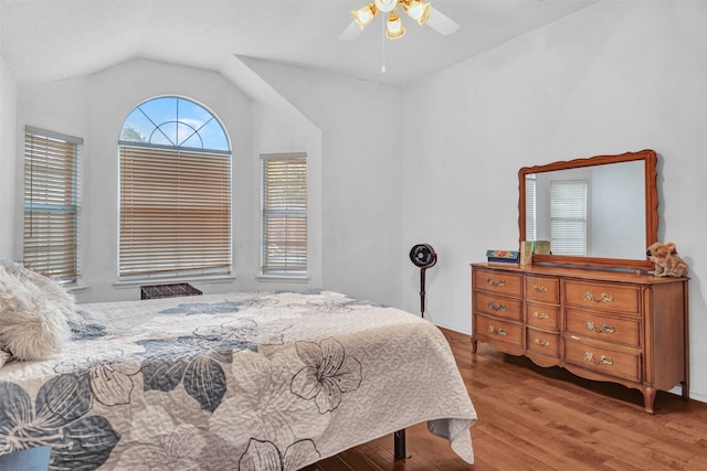 bedroom featuring light hardwood / wood-style floors, vaulted ceiling, and ceiling fan