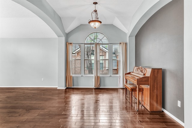 interior space with dark wood-type flooring and vaulted ceiling