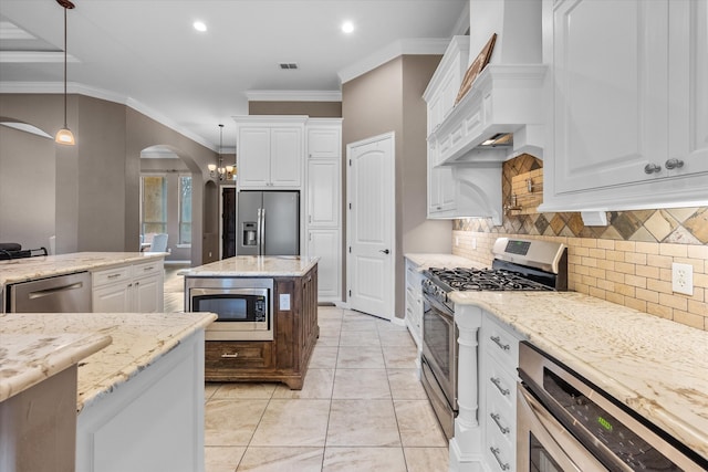 kitchen with white cabinets, hanging light fixtures, and stainless steel appliances