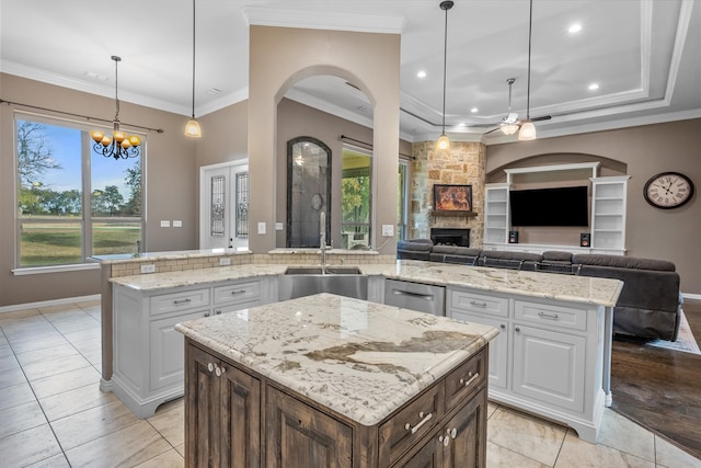 kitchen with ornamental molding, white cabinetry, a kitchen island, and pendant lighting