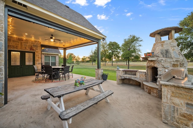 view of patio / terrace featuring an outdoor stone fireplace, area for grilling, and ceiling fan