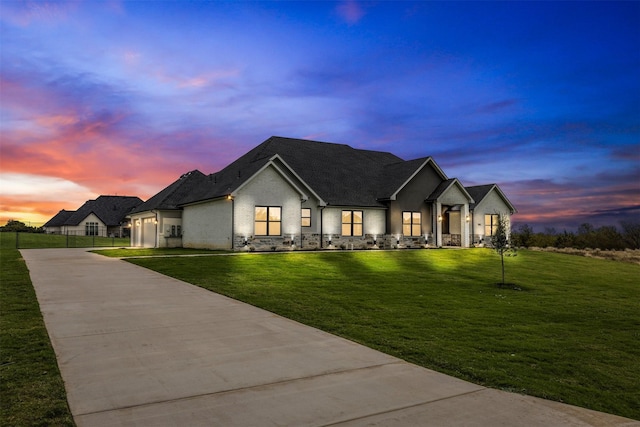 modern farmhouse style home featuring concrete driveway, an attached garage, a front lawn, and fence