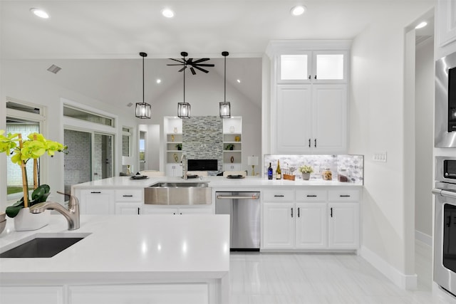 kitchen featuring a sink, stainless steel appliances, hanging light fixtures, and light countertops