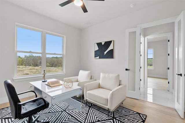 office area featuring light wood-style floors, ceiling fan, and baseboards