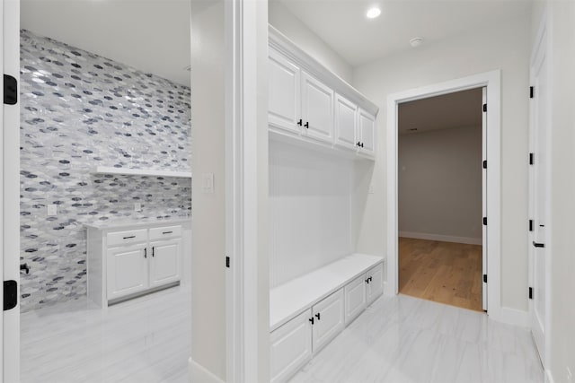 mudroom with an accent wall, recessed lighting, and baseboards