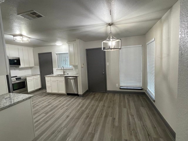 kitchen featuring stainless steel appliances, dark hardwood / wood-style floors, and white cabinets