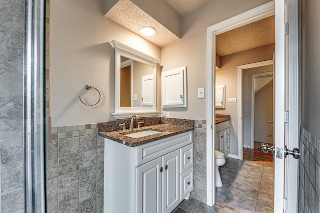 bathroom with vanity, a textured ceiling, hardwood / wood-style flooring, and toilet