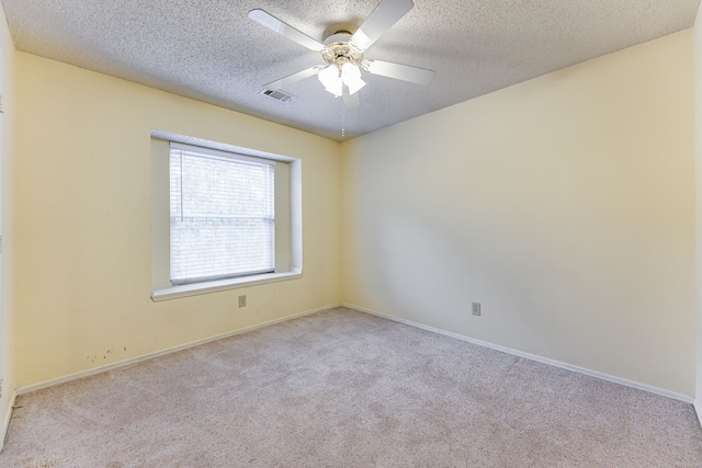 empty room with light carpet, a textured ceiling, and ceiling fan