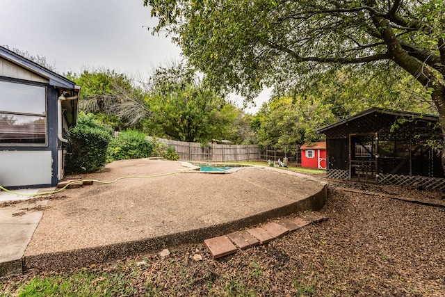 view of yard with a storage shed and a patio