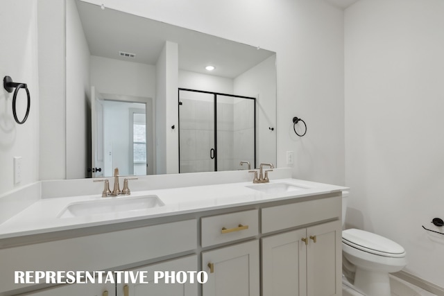 bathroom featuring vanity, toilet, and a shower with shower door