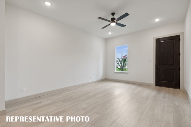 empty room featuring ceiling fan and light hardwood / wood-style flooring