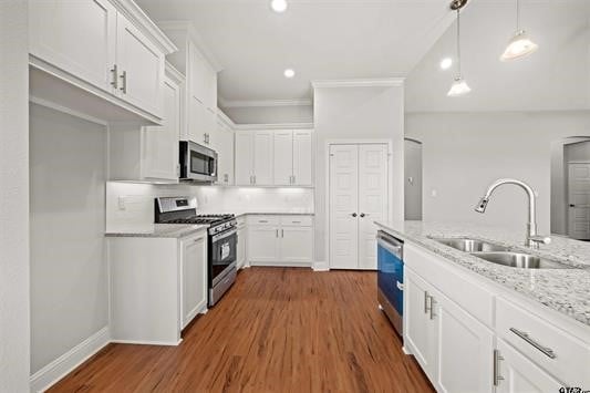 kitchen featuring dark hardwood / wood-style floors, sink, white cabinets, appliances with stainless steel finishes, and light stone counters