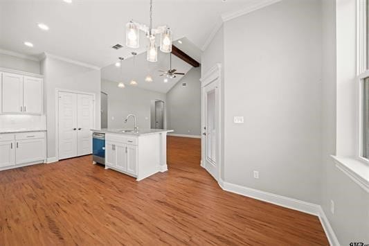 kitchen featuring lofted ceiling, white cabinetry, hardwood / wood-style flooring, and an island with sink