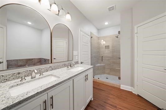 bathroom with vanity, hardwood / wood-style flooring, and a shower with shower door