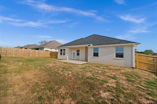 rear view of house featuring a yard and a patio area